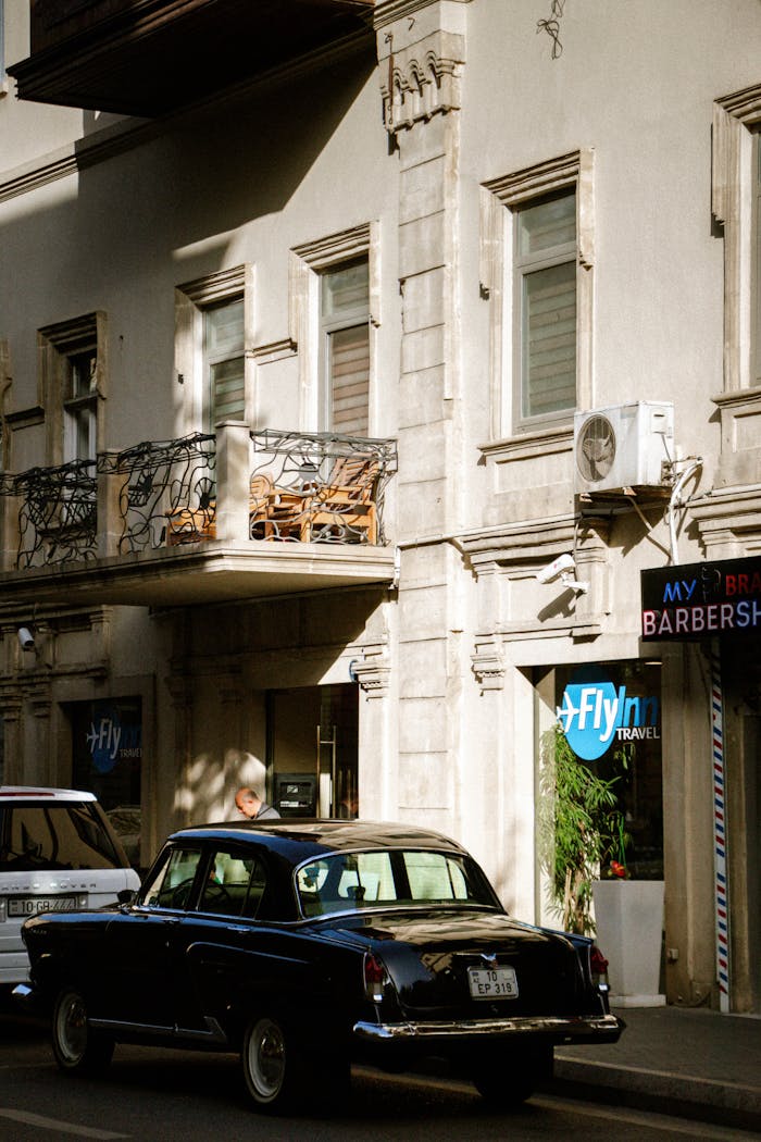 Classic vintage car parked on a sunlit street in Baku, Azerbaijan.